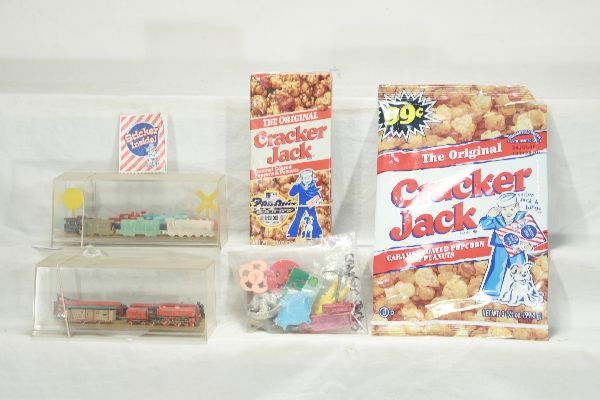NETTE - CRACKER JACK Premiums Lot: Several tin, Cast metal & plastic trains in display case; several assorted tin & plastic pieces, 1 original box & original bag, as per photo.