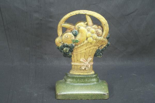 1930s Cast Iron Door Stop: Probably Hubley, nice fruit basket motif, muted tones shows some edge wear, 10" tall. For Bigger and Better photos or information about consigning in our future events go to our website