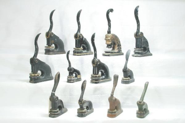 12 Early Cast Iron Seals: Most from Waterbury, Connecticut companies, 1 has unusual lion head shape. For Bigger and Better photos or information about consigning in our future events go to our website