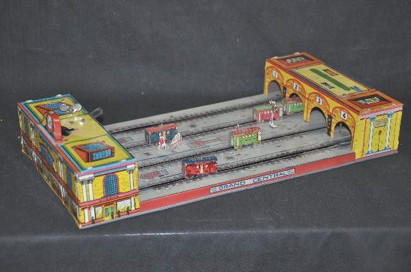 Katz Grand Central Station: Circa 1920s, litho tin, mechanism functional, but needs adjustment, missing 1 lamppost, 16" Long, shows moderate wear, should clean nicely. For Bigger and Better photos or information about consigning