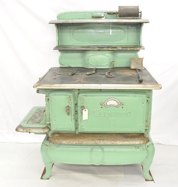 1926 Glenwood Cast Iron Stove: 45 x 30 x 52" Model 208, original porcelain finish, plating shows age and signs of use, deluxe model with temperature indicator on door, includes grate and ash bin with original shovel, as well as gra