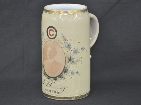 1899 Mettlach Portrait Stein: Half liter porcelain stein, portrait centered in hand painted poppy vignette, shows what appears to be a Chicago Cubs baseball logo above, signed F. J. Leahy, November, 1899, gilded top and bottom rim