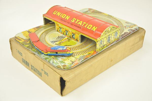Mystery Union Station: Circa 1930's, Automatic Toy Company, Mystery Union Station. 20" x 14" litho tin platform and structure and 3 car train set. Mechanism functional. Original box, shows light playwear.