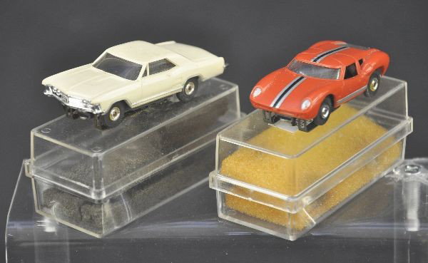 Two Aurora T-Jets Slot Cars - HO Scale: One Red Ferrari, minor wear to top stripe, Galaxy 500, white. Both have boxes with no inserts, foam worn. Both show light playwear.