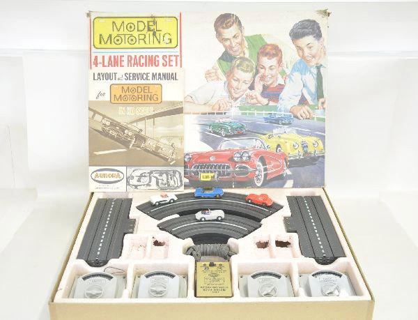 Aurora 4-Lane Racing Set #1505 in HO Scale: Aurora #1505 4-lane racing set dated 1962, vehicles include light gray Jaguar with red interior and black boot, blue T-Bird coupe roof painted outside, Corvette with red interior and Jaguar coupe, mis