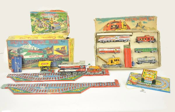 Three Boxed Tin Train Toys: SSN Battery operated freight set, silver train locomotive with controller, boxcar, tankcar, crane, gondola and caboose, original set box and insert rough; TPS Magic Tunnel Train 9" x 6" base, mechanis