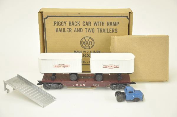 Scarce boxed Marx 5545 Piggy Back Car: White lettered flat car on G trucks, with Burlington trailers in original box. Includes ramp and blue hauler. Condition: trailers are clean and shiny, hauler has some wear to plating on bumper, origin