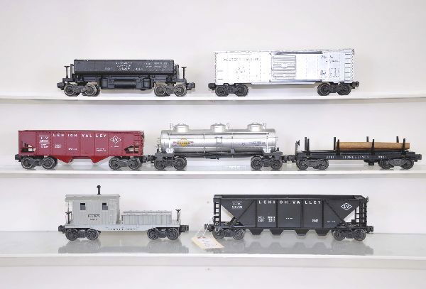 Seven Lionel Freight Cars: 3469 ore dump, 6436 quadhopper, 6415 tank car, bright silver, 6456 hopper, 6464-1 Western Pacific boxcar, Type 1, 3461 lumber dump with load, 6419 work caboose, Condition: all clean, lumber car has sm
