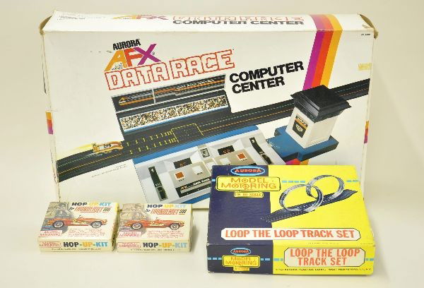 Four Boxed Aurora Slot Car Accessories: Thunderjet Loop-the-Loop Track Set #1504 in HO Scale in original box with instructions, missing straight track connecting section. Box bright and clean, shows light playwear; Two #1462-98 T-Jet Hop-Up