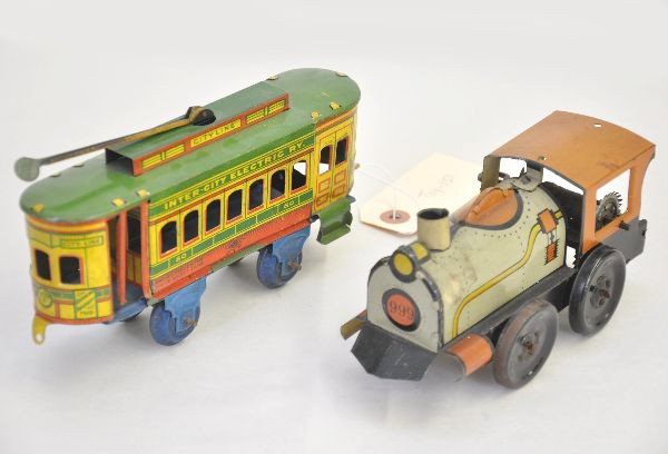 Two Early Train Toys: Nonpareil #80 Inter City Collector Trolley, litho tin 8" long, 7" 999 steam loco floor toy, mechanism slipping, unmarked. Both show light to moderate playwear. C7