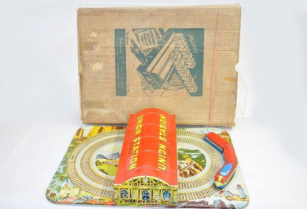 Mystery Union Station: Circa 1930's, Automatic Toy Company, Mystery Union Station. 20" x 14" litho tin platform and structure and 3 car train set. Mechanism functional. Original box, shows light playwear.