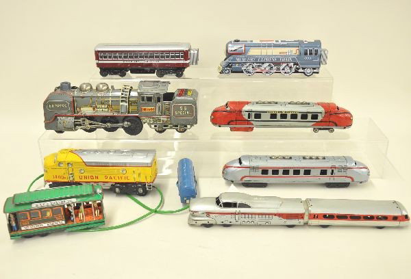 Eight Tin Train Toys: Mercury Express train with coach; Union Pacific battery operated diesel; Powel and Mason trolley; TN Japan 55 Special steam engine and tender, battery operated; San Aerotrain 17" long; two different e