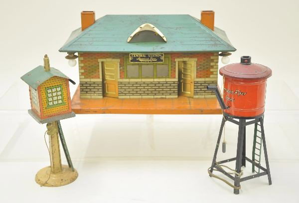 Three Pre-War American Flyer Accessories: 215 water tank with light, 109 central station with brass trim; 216 switch tower with bell. All show moderate playwear. Should clean to C6