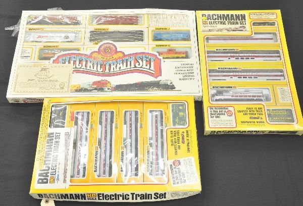 Three Mint Bachmann HO Gauge Train Sets: 0270 Amtrak Metroliner Set, power car and 3 trailers; 0280 Auto-Train, U36B diesel and 3 cars; 950-619 Zenith Special which has diesel with 5 freight cars. All have track and transformer. Sets are fac