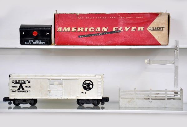 Boxed American Flyer S-Gauge 973 Milk Car: Lettering strong, but needs a cleaning. Includes 6 cans, platform, controller and activator. Original box with insert, missing top. Otherwise, shows light to moderate playwear C7-