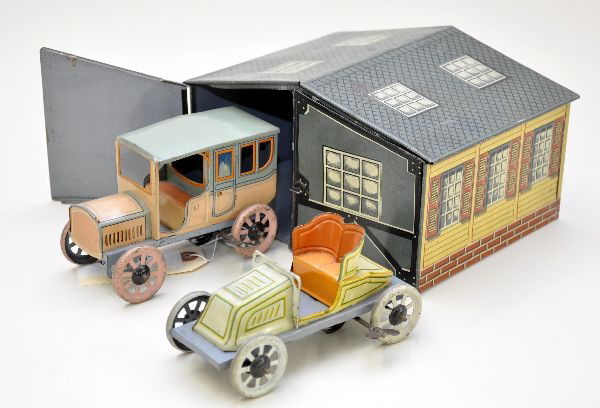 Nice Bing Auto Garage: Circa 1920s, litho tin with two clockwork vehicles, both are functional. Comes with a nice tin garage and shows light to moderate playwear, C7-7+