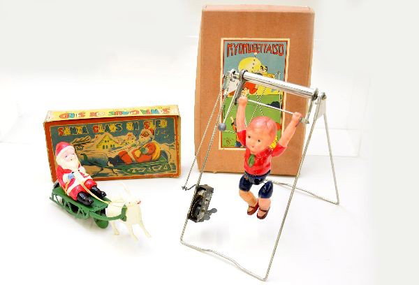 Boxed Early Celluloid Toys: 8" Santa Claus on sled, mechanism functional with bell and an acrobat 9" tall with functional mechanism. Both are like new, original boxes show some wear, C9