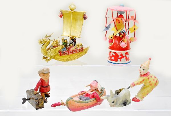 Early Japanese Toys: Celluloid Indian in canoe; mechanical porter with celluloid figure, one arm is loose, mechanism is functional; clown and donkey toy, celluloid, mechanism functional; baby chick carousel, mechanism fun