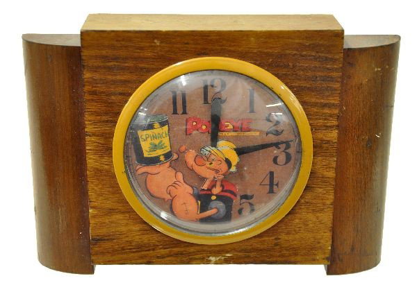 Rare United Popeye Character Clock: Scarce art deco clock, 9 1/2" x 6 1/2", with walnut case, paper color dial, copyright 1938. Popeye's head is attached to the minute hand and rotates with the time. Case shows some wear but very scarce