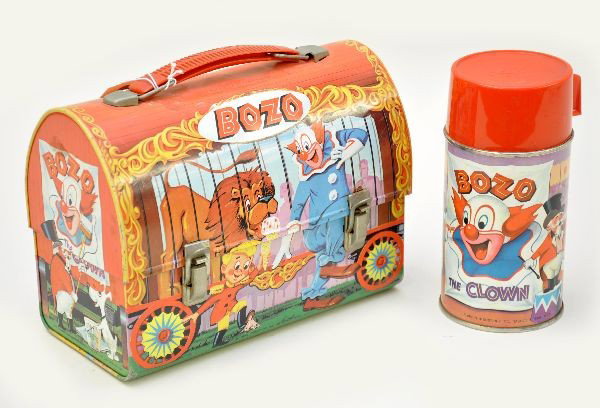Nice Bozo Domed Lunch Box: Aladdin Industries, dated 1963, bright, clean and shiny with minor dents on roof. Includes original metal thermos. A few small oxi spots on chrome. Otherwise, shows light playwear.