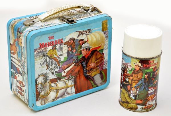 The Monroes Western Lunch Box: Aladdin Industries 1967, embossed The Monroes lunch box. Still retains partial original outside label with metal thermos. Shows light to moderate wear.