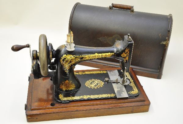 Early Singer Sewing Machine: Last patent date 1887, ornate stenciling on cast iron structure, measures 12" x 7" x 8", crank action. Original wooden carrying case, shows some wear. Appears complete and functional.