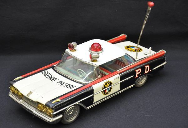Unusual Japanese 1959 Oldsmobile Police Car: Large size at 13" long, friction drive with moving top lights and battery operated bubble light, working, missing battery cover, nicely appointed with brass and nickel trim. Otherwise, shows light pla