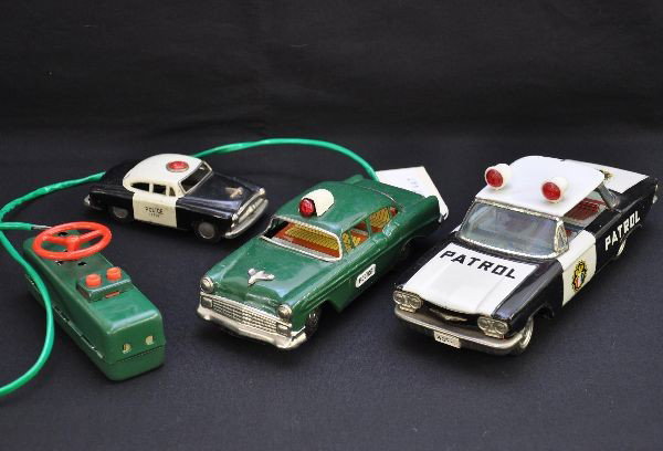 3 Japanese Tin Police Cars: Ichico, Japan, 9" 1964 Chevrolet Corvair, friction with swinging lights, shows moderate playwear; 5" 1954 Pontiac friction sedan, C7; Marx 7 1/2" 1957 Pontiac, battery operated, mechanism functional w