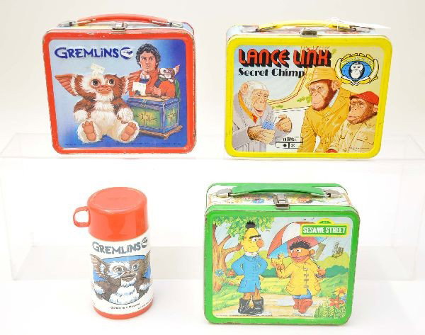 Lunch Box Lot: Lance Link, King-Seeley 1971, shows light wear; Gremlins, Aladdin Industries 1984 with plastic thermos; Sesame Street, Aladdin Industries 1983. Otherwise, boxes show moderate wear.