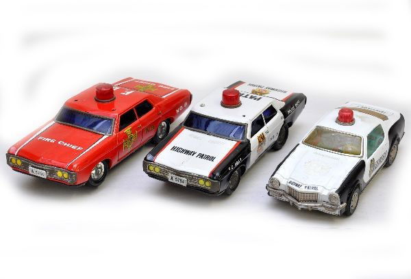3 Battery Operated Emergency Vehicles: 1966 Oldsmobile highway patrol and fire chief car, both are battery operated and functional with blinking lights, sirens and mystery action. Both are missing plastic secondary lights. 1974 Camaro poli