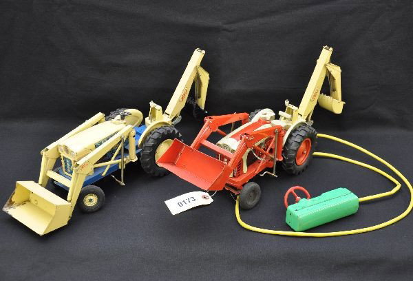 Japanese Ford 1841 Backhoes: Each about 19" long and all litho tin & battery operated. Red tractor functions forward and reverse with blinking light in motor but other operations did not work at time of test. Yellow tractor is mi