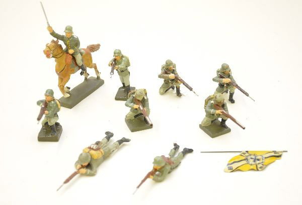 Composition German Soldiers: Mixture of Lineol and Schusso figures. Scarce figure includes prone firing with cap mechanism. Also includes tin German national flag. Overall, shows light to moderate wear, C6-8