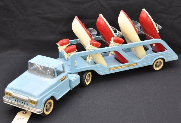 Scarce 1961 Tonka Boat Loader: Painted pressed steel with original plastic Tonka deluxe boats, 27" overall length. Complete as issued plus two additional motors, one is a late version and cracked. Truck has a cracked windshield and