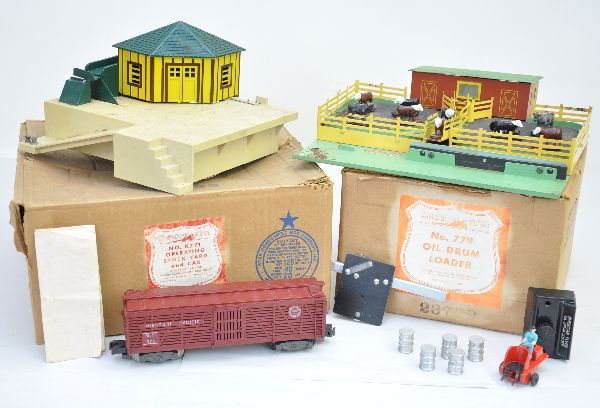 Boxed American Flyer Accessories: S-Gauge. 779 oil drum loader, complete minus steering wheel; 771K stock yard with 976 operating stock car, some rust spots on track base extension. Both have their original boxes and otherwise show li