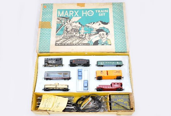 Boxed Marx HO Set 17870: Includes NYC steam switcher; LV hopper; C&O gondola; Erie auto loader, missing 2 cars; SF boxcar; RF tank car; NYC work caboose; accessory set; track & transformer; set box with inserts. Trains show l