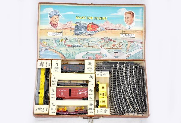 Boxed Marx HO Suitcase Set: SF GP7 diesel; LV hopper; LV railed flat with lumber; UP boxcar; IHCX flat with dozers, no treads, 1 is worn; SF bay window caboose. All have individual boxes, track, suitcase set box. Trains show lig