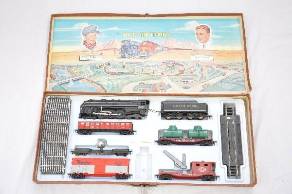 Boxed Marx Suitcase Set: 6096 Hudson loco & tender, WM gondola, SC flat with tanks, GEX searchlight, Pacemaker boxcar, NYC boom crane, caboose, track, and suitcase set box. Trains show light playwear, C7+