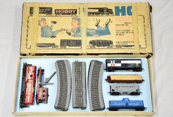 Boxed Marx Allstate HO Set: Includes a Monon GP9 diesel; Allstate tank; cement car; Erie log car; NH boxcar, Monon boom crane caboose, roadbed track and worn set box with insert. Trains show light to moderate playwear C7