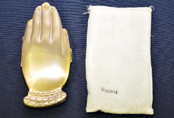 Unusual Volupte Golden Gesture Compact: Circa 1946, 4 1/2" long, gold plated brass color in shape of human hand, each side. Interior has spring loaded compact with original pad and mirror. Shows light signs of use and comes with its origina