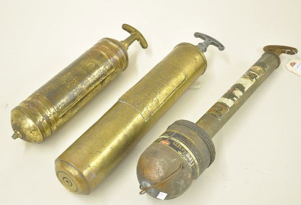 Early Brass Fire Extinguishers: 14" Pirene, last patent date 1912, fluted brass; 19" Garfire Gun by Garrison Engineering, Waterbury, CT, some wear to decals; 17" Safety Phlare Pump by Buickaid. All show signs of wear and use.