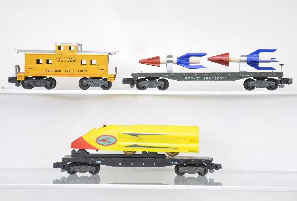 American Flyer Freight Cars: S-Gauge. 25515 USAF flat with rocket sled and original figure; 24553 rocket transport car; 24632 radio caboose. All show light to moderate playwear, C7