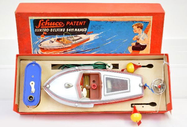 Boxed Schuco 5411 Navico: 9 1/2" plastic Elektro-Delfino speed boat, battery operated. Includes both buoys with anchors, one is incomplete, speed control, tether and battery box. Nice original box with display insert, shows li