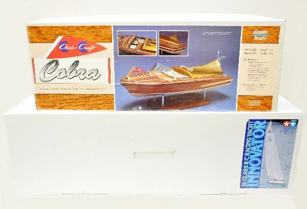 Boxed Large Wooden Boat Kits: Tamiya, racing yacht The Innovator, kit is new in box, box is 39" long; Dumas, 1232 Chris-Craft Cobra speed boat, mahogany. Both are RC compatible. Both have original boxes and appear complete. (compl