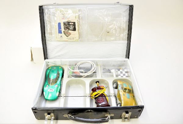 1/32 Scale Slot Cars: Standard Plastics carry case with inserts, two slot cars with Gar Bic chassis, two controllers, decal sheets and instructions. Gold car shows heavy paint wear but plastic is intact. Otherwise, shows m