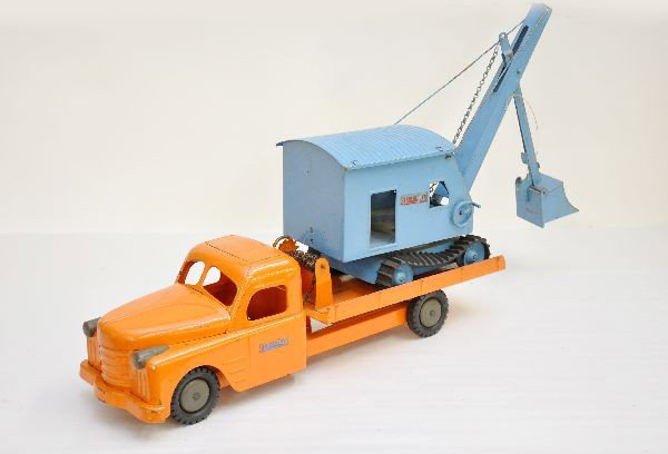 Structo Machinery Hauler with Shovel: Circa 1955, painted pressed steel with rubber tires, truck is 21" long, hood opens. Includes original steam shovel with original treads, has some wear to decals, has original, clean, shiny patina. Sho