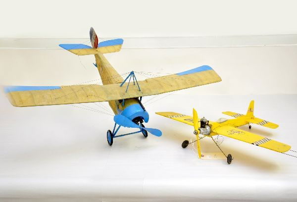 2 Model Airplanes, One Gas: Both balsa construction, yellow plane marked Swordsman has 17" wingspan, tether controlled, gas powered motor; early mono-plane with 28" wingspan, rubber band drive. Both show moderate signs of use an