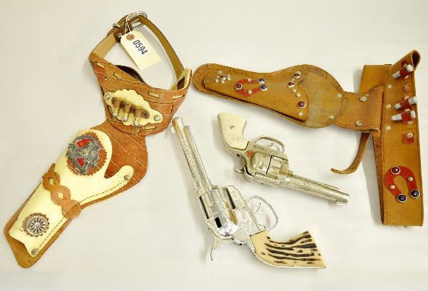 2 Cap Gun & Holster Sets: Mattel Fanner 50 with ornate holster and 3 bullets and a Hubley cowboy cast iron pistol with holster set with 7 of 8 original bullets, one bullet loop is apart. Both show light to moderate playwear, C