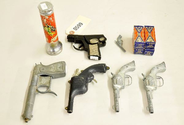 Toy Gun & Caps Lot Plus: Includes a pair of Hubley Roy Rogers 6" cap guns, miniature revolver, 4 boxed Star brand caps, 5 3/4" cowboy flashlight, decal shows moderate wear, Cossman spud gun, early 1914 bell ringing clicker gu