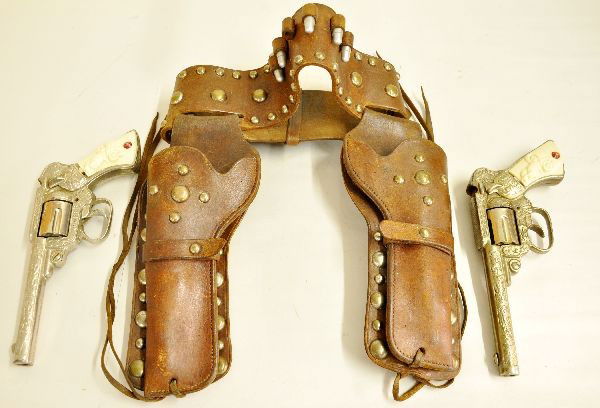 J&E Stevens 49er Cap Pistol Set: Super double holster set with 2 cast iron 49er cap pistols. One in silver finish, other gold. Both functional cap fill doors are tight because of interior rust, but cleanable. Super leather holster se