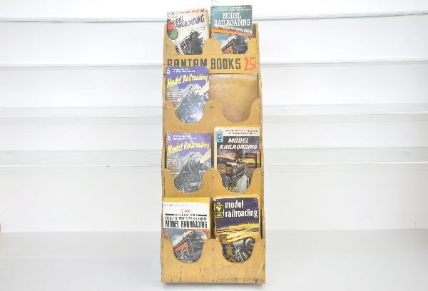 Lionel Books & Book Rack: All eight variations of Model Railroading, edited by Lionel, plus a Bantam 25 cent book display rack. All show light signs of use and age.